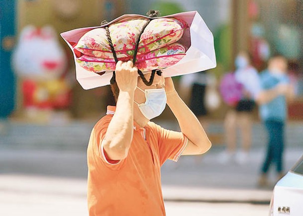 深圳市一位市民頭頂袋子遮擋陽光。（中新社圖片）