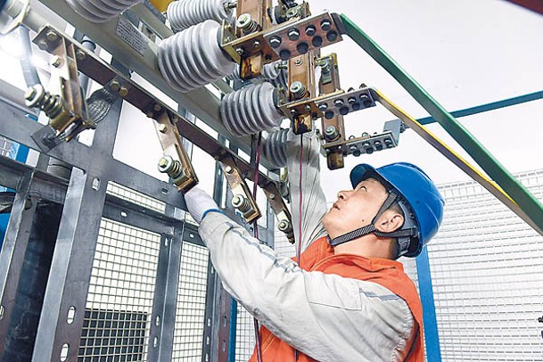 重慶市電力員工檢修電容器設備。（中新社圖片）