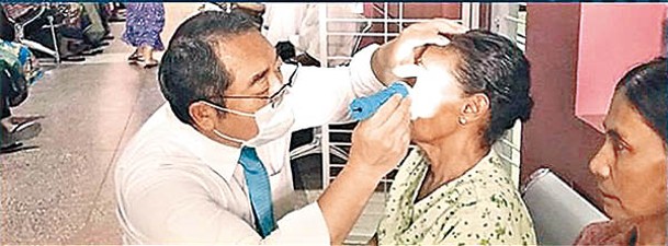 服部匡志（左）在越南為有需要人士提供免費治療。