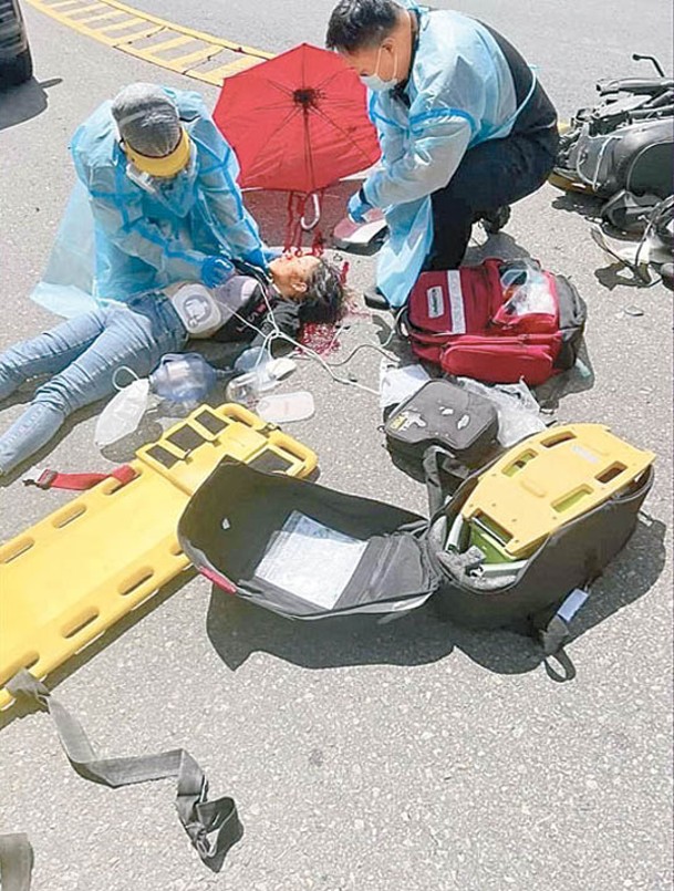 救護員為電單車女司機急救。