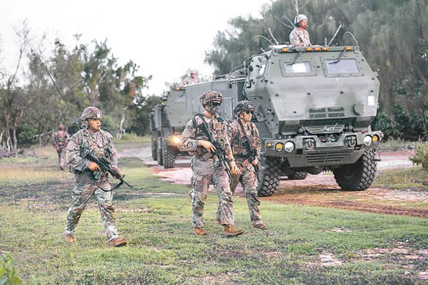 美國陸軍士兵護送M142高機動火箭系統發射車到射擊陣地。