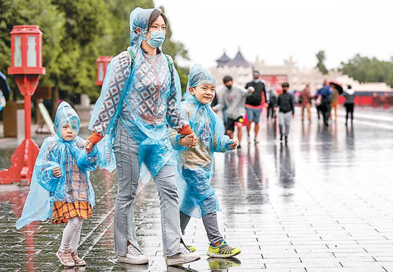 民眾在雨中遊覽北京市天壇公園。（中新社圖片）