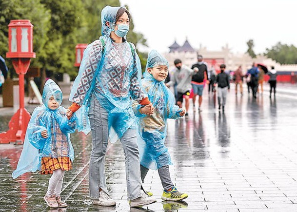 民眾在雨中遊覽北京市天壇公園。（中新社圖片）