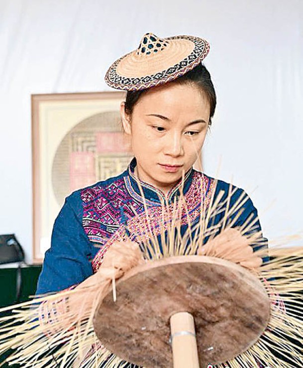 覃敏（圖）向母親譚素娟學習編織花竹帽。