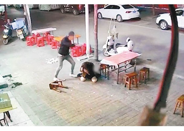男子在街頭毆打女受害人。