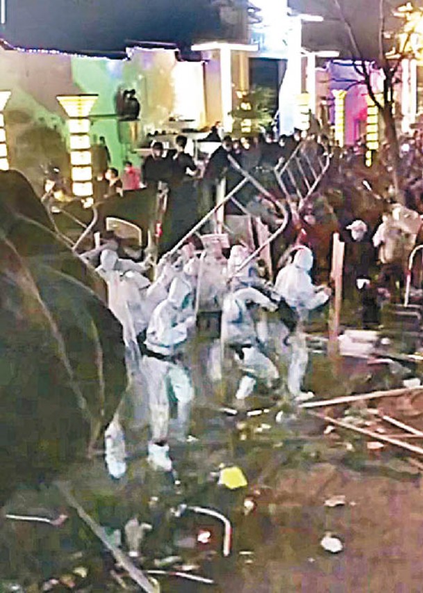 白色防護衣人遭員工衝擊。