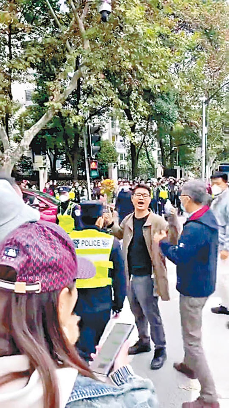 上海：一名男子手持鮮花演講，其後被警員帶走。