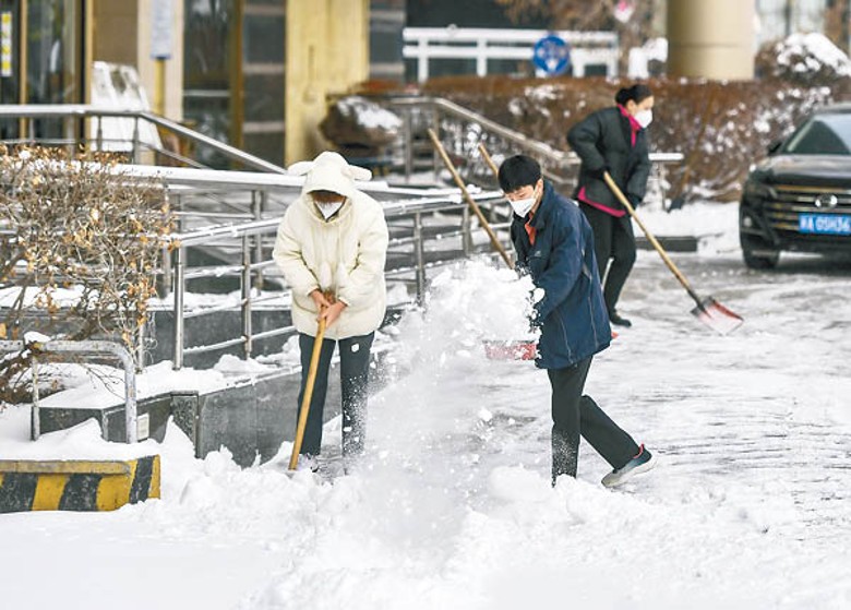 新疆：烏魯木齊市民用滑剷清理積雪。