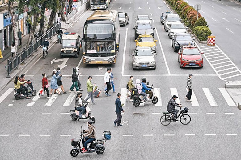 廣州市解封，海珠區市民戴口罩出行。（中新社圖片）