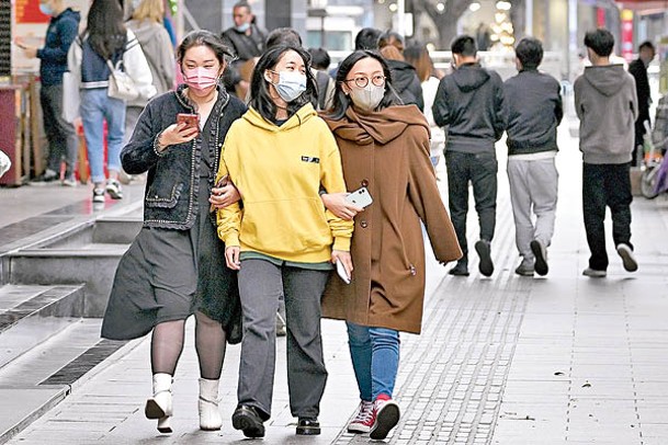 廣州民眾穿上厚衣。（中新社圖片）