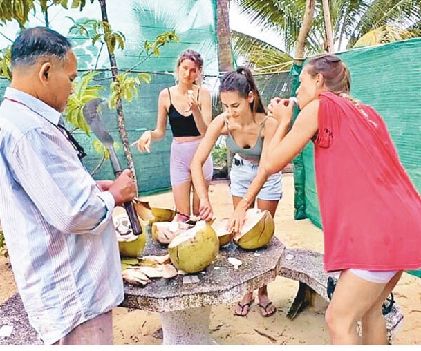 女遊客獲島民以椰青招待。