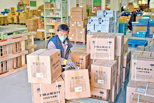 北京市一個物流中心的工作人員搬運藥品。（中新社圖片）