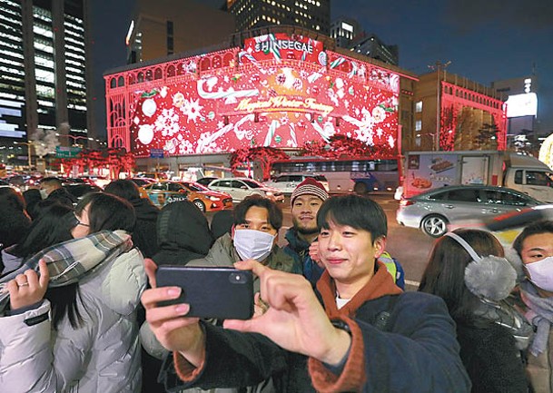 首爾：南韓民眾對着聖誕燈飾拍照打卡。（Getty Images圖片）