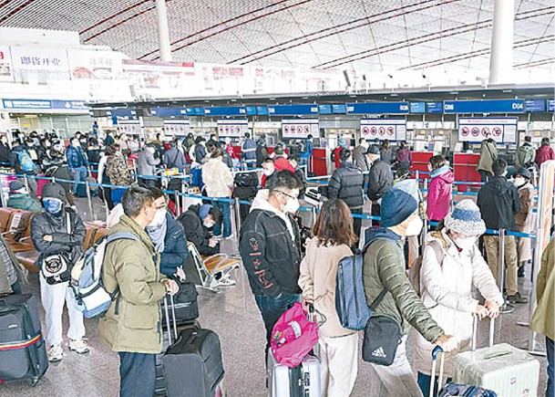 旅客在北京首都國際機場排隊辦理登機手續。（中新社圖片）