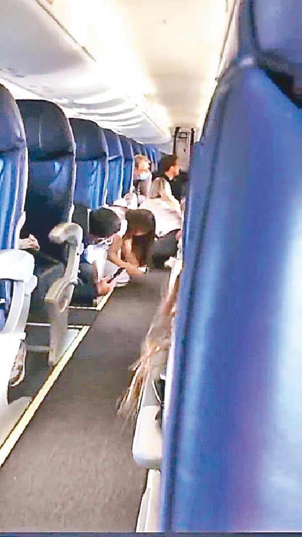 客機乘客俯伏身子躲避。