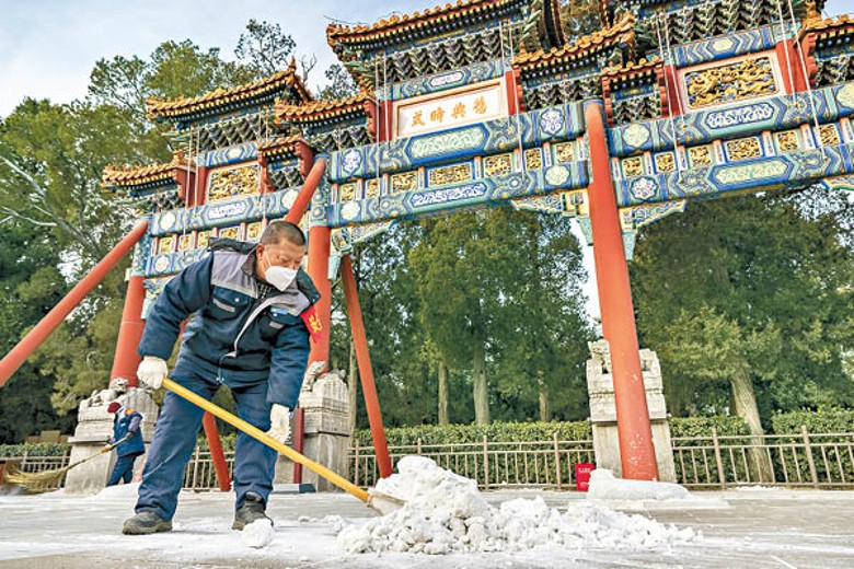 北京工人剷除路面積雪。