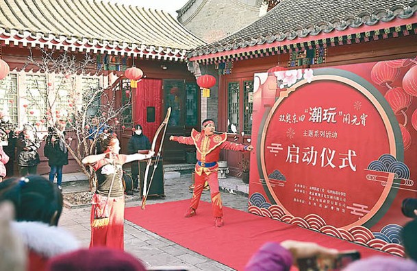 北京市民駐足觀看拉硬弓表演。（中新社圖片）