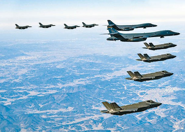 美國兩架B1B超音速轟炸機（中）及F16戰機（上）與南韓F35A隱形戰機（下）組成空中編隊演練。（Getty Images圖片）
