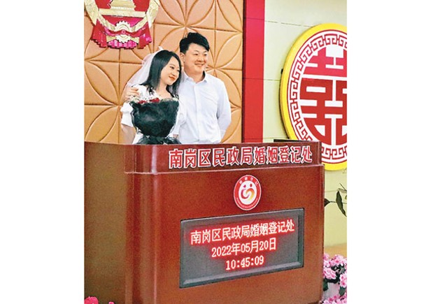 新婚夫妻在結婚證頒證處拍照留念。