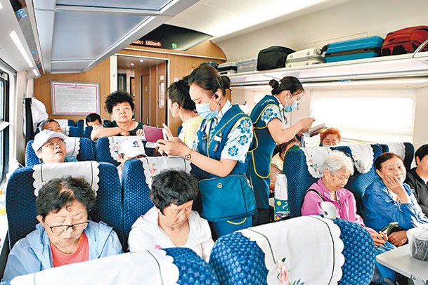 列車員為旅客登記出境訊息。（中新社圖片）