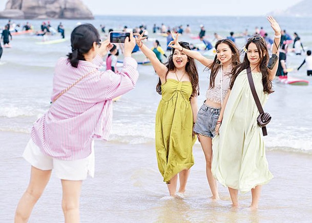 遊客在海南三亞後海皇后灣沙灘拍照打卡。（中新社圖片）