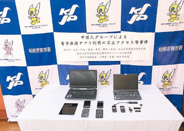 日本警方展示涉案手提電腦等電子設備。