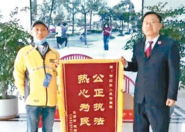 王雪峰（左）獲頒錦旗。