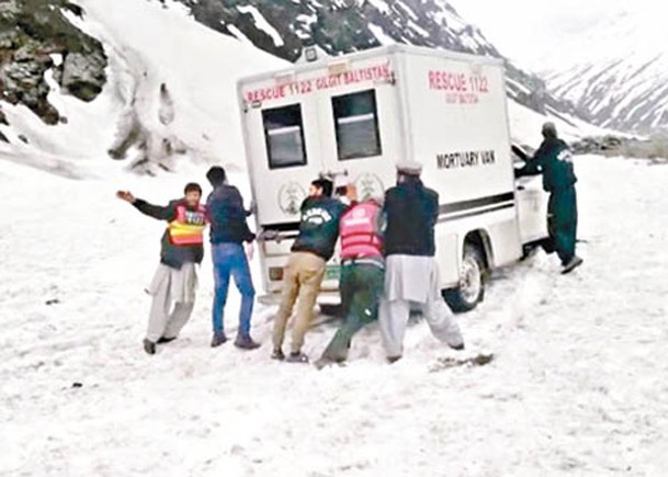 由於地面出現積雪，搜救人員合力推車。