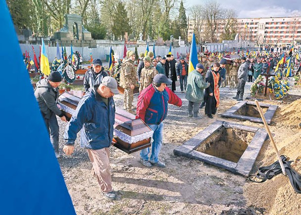 烏克蘭士兵準備在利沃夫埋下靈柩。（Getty Images圖片）