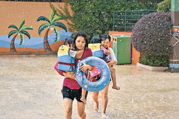 廣東廣州一個水上樂園的遊客前往室內避雨。（中新社圖片）