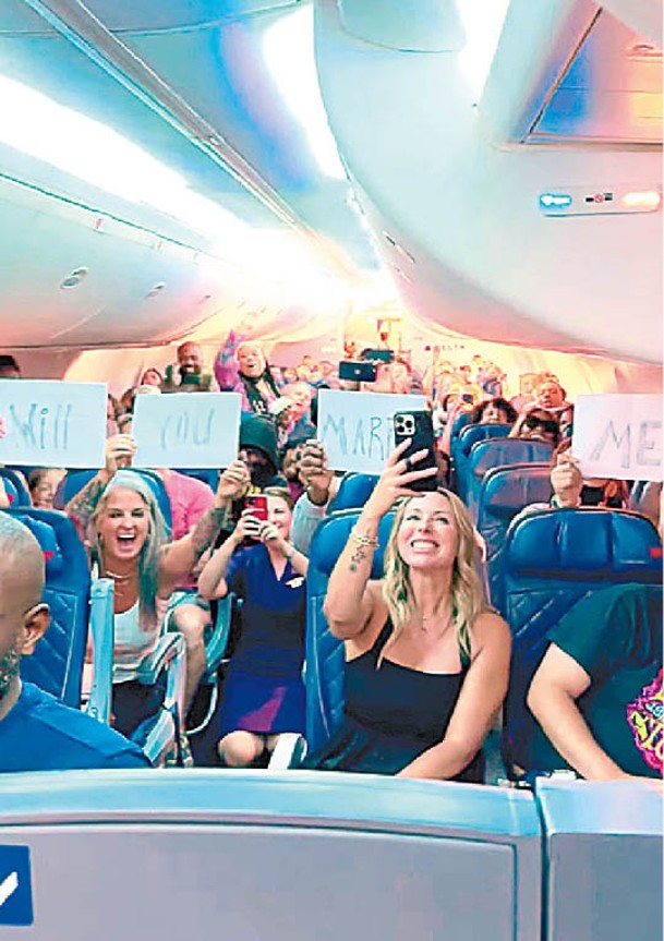 機上乘客舉紙張相助。