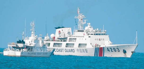 中國海警船（右）在南海攔截菲律賓巡邏船（左）。