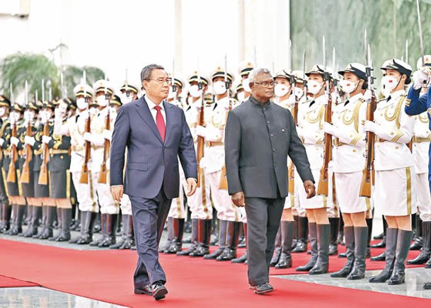 中國國務院總理李強（左）與所羅門群島總理索加瓦雷（右）在北京人民大會堂出席歡迎儀式。（中新社圖片）