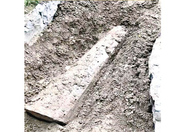 墳墓明顯被人挖開，露出棺木。