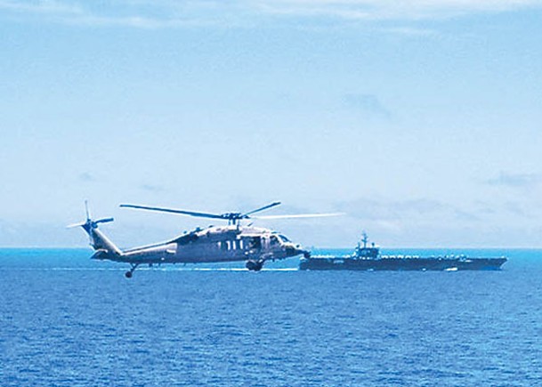 網上照片顯示美軍直升機為航空母艦列根號（後）護航。
