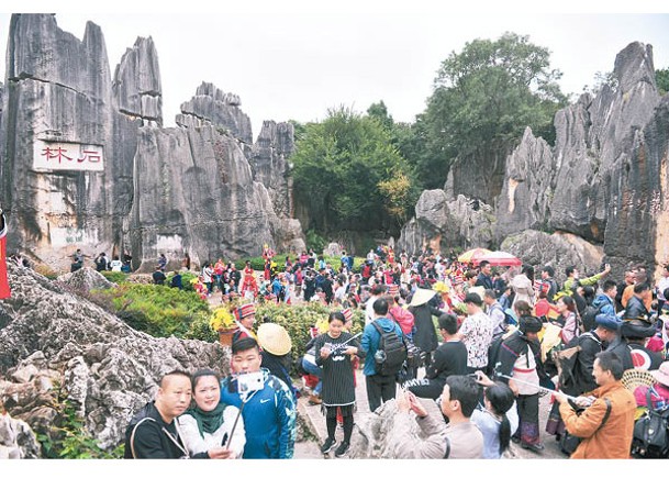 大批遊客在雲南石林風景名勝區拍照留念。（中新社圖片）