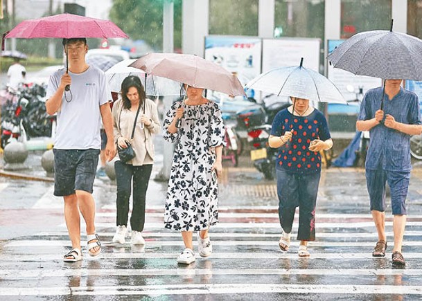 北京市持續降雨，市民冒雨出行。（中新社圖片）