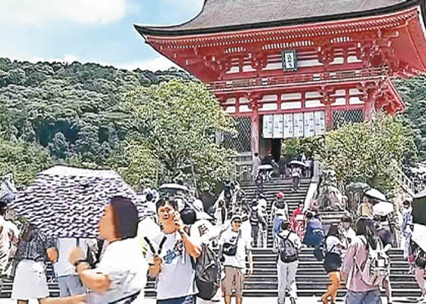 京都市清水寺不少遊客手持雨傘遮擋陽光。