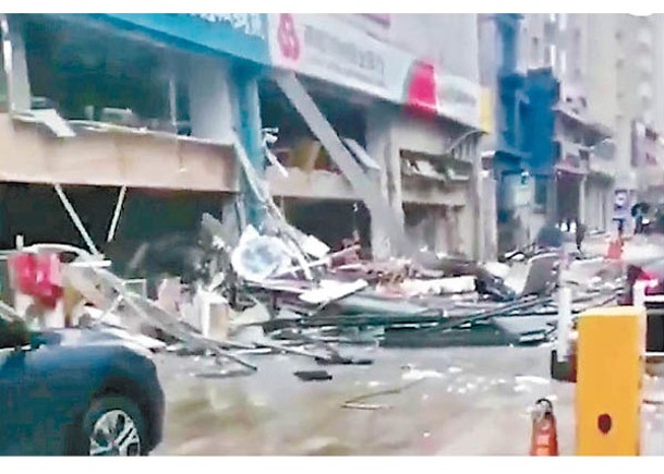 爆炸後烤魚店外堆滿建材碎片。