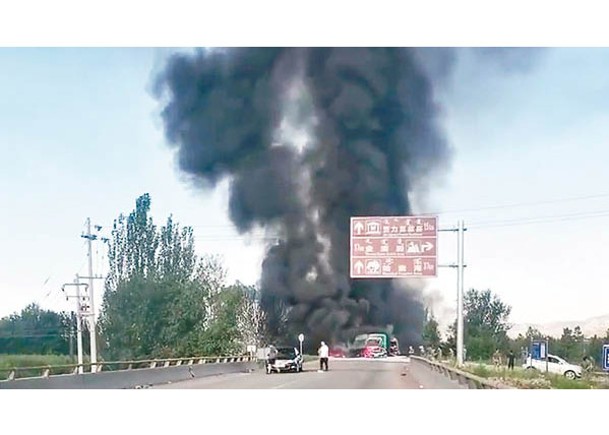 兩輛貨車相撞後起火，冒出濃濃黑煙。