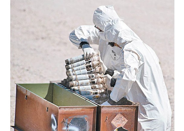 美國軍方人員身穿防護裝備移走貧鈾彈。