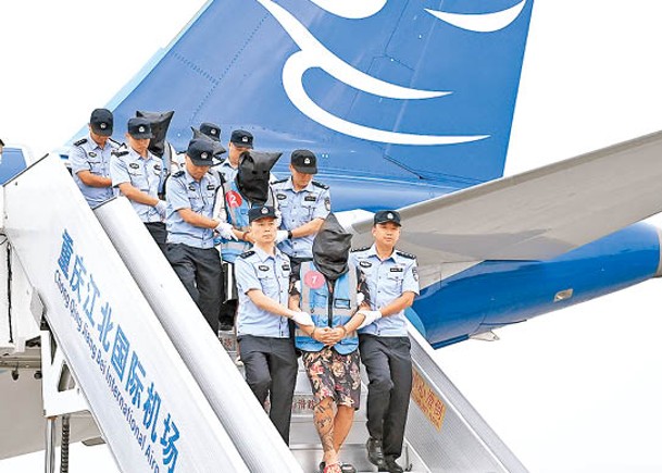 重慶警方押解疑犯從老撾回國。