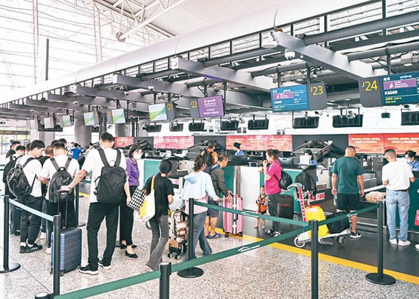 旅客在廣州白雲機場辦理登機手續。（中新社圖片）