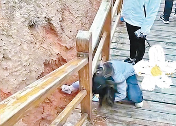一名遊客被拍到在七彩丹霞景區挖土壤並裝袋帶走。