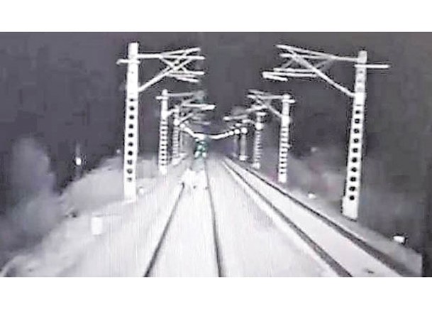 監控錄影拍到兩人翻越鐵路防護網進入線路行走（中）。