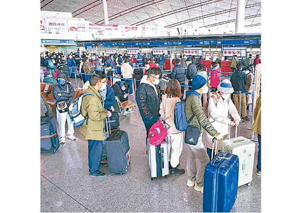 旅客在北京首都國際機場排隊辦理登機手續。（中新社圖片）