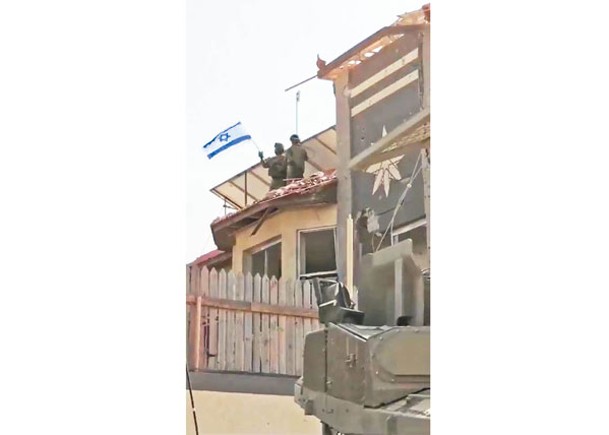 以色列士兵在加薩地帶北部地區揮舞以色列國旗。