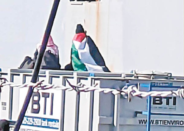 示威者身披巴勒斯坦旗幟。