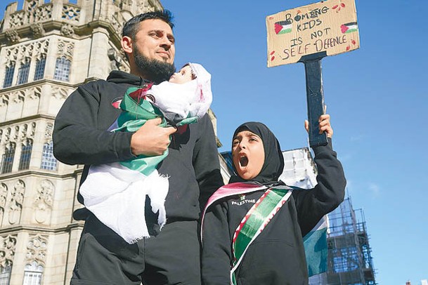倫敦示威者攜帶模擬被炸死的嬰兒公仔。<br>（Getty Images圖片）