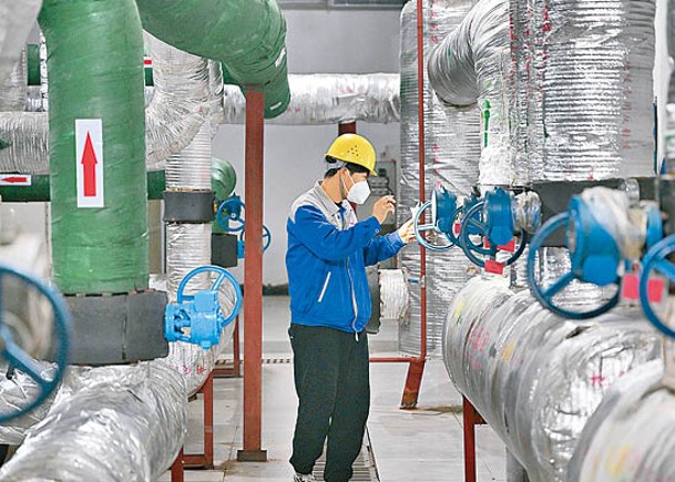 寧夏銀川熱力部門工作人員檢查換熱站設備。（中新社圖片）